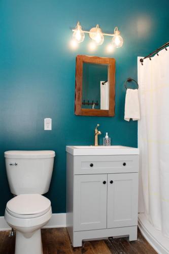 a bathroom with a white toilet and a mirror at Bischoff Inn - Former 1870 Furniture Factory Now 5 Room Boutique Hotel in Tamaqua