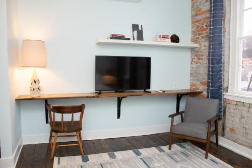 a living room with a tv and two chairs at Bischoff Inn - Former 1870 Furniture Factory Now 5 Room Boutique Hotel in Tamaqua
