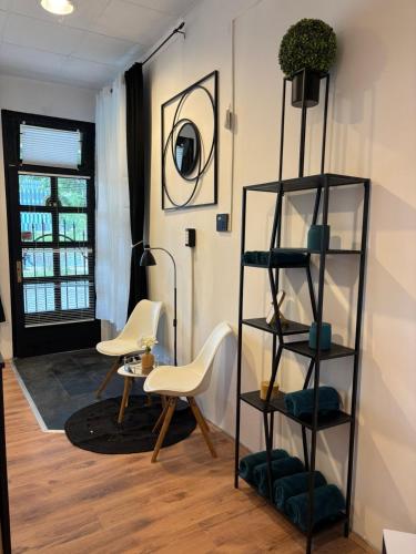 a living room with chairs and a book shelf at Studio Lent Riverstay in Maribor
