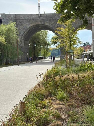 a bridge over a road with people walking under it at Studio Lent Riverstay in Maribor