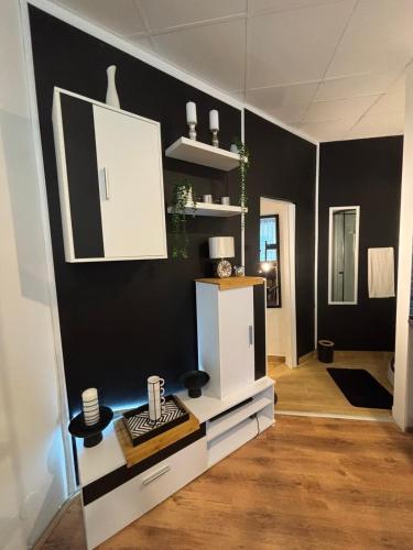 a living room with a white cabinet and black walls at Studio Lent Riverstay in Maribor