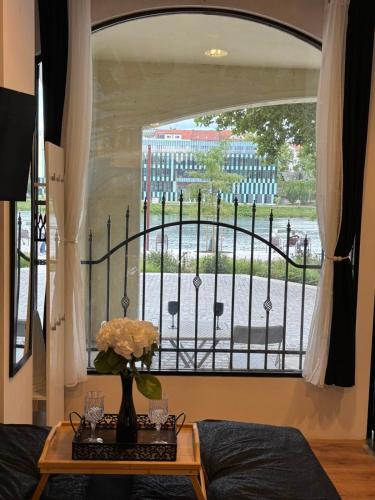 a room with a window with a vase of flowers on a table at Studio Lent Riverstay in Maribor