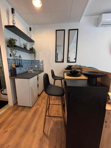 a kitchen with a black counter and a chair at Studio Lent Riverstay in Maribor