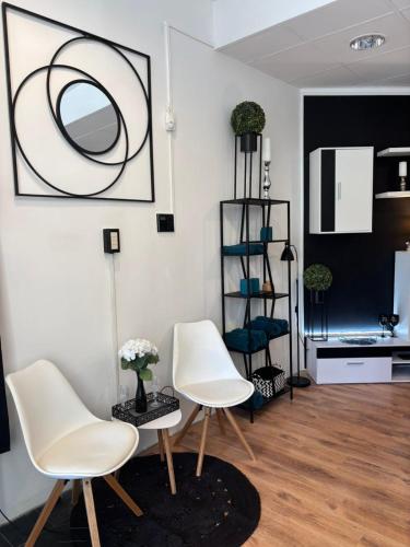a living room with white chairs and a table at Studio Lent Riverstay in Maribor