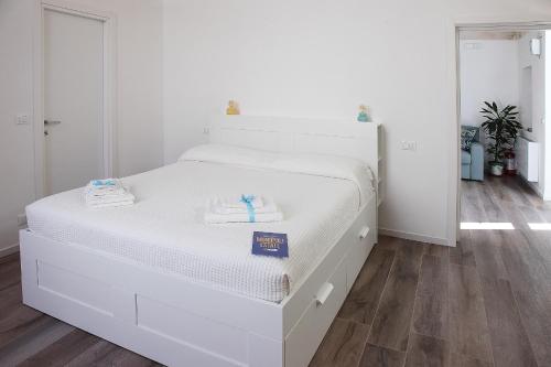 a white bed with two towels on it in a bedroom at LucAsia in Monopoli