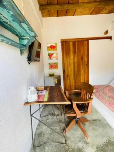 a desk and chair in a room with a bed at Casa Dibulla Hotel Boutique in Dibulla