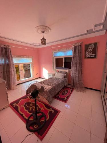 a bedroom with a bed in a pink room at Gîte à la ferme khemissat 