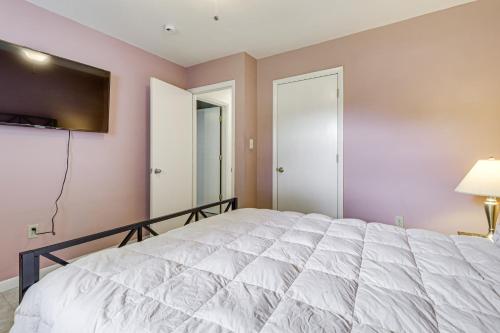a bedroom with a white bed and a flat screen tv at Riverfront Fun Quiet Home Near Hampton Coastline in Hampton