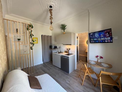 ein Zimmer mit einem Bett und eine Küche mit einem Tisch in der Unterkunft Studio Fonctionnel à Nice - Télétravail et Séjour Pro - Plage à 300 m in Nizza
