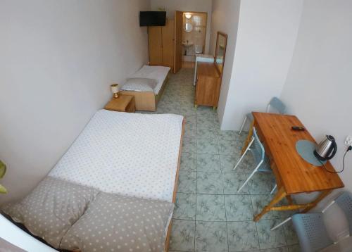 a room with two beds and a table and a desk at Dom Gościnny Wika in Rewal