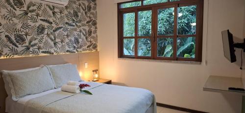 a bedroom with a bed with a teddy bear on it at Villa do Cajueiro Imbassaí in Imbassai