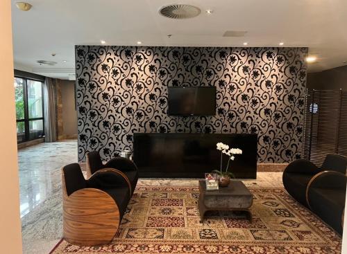 a living room with a fireplace and a television at Hotel Wydn Ibirapuera Moema in Sao Paulo