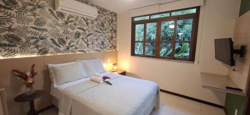 a bedroom with a bed with a teddy bear on it at Villa do Cajueiro Imbassaí in Imbassai