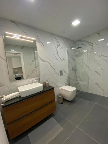 a bathroom with a sink and a toilet and a mirror at Alex Guest House in Quinta do Anjo
