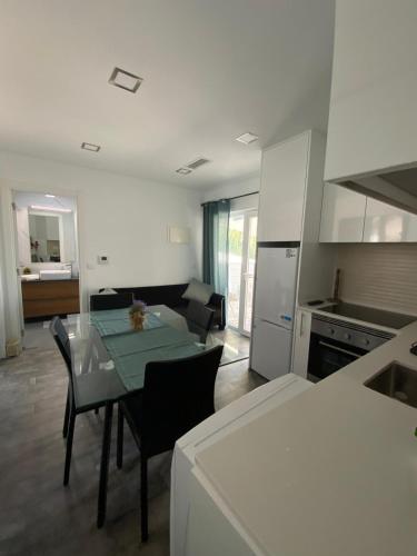 a kitchen and living room with a table and chairs at Alex Guest House in Quinta do Anjo