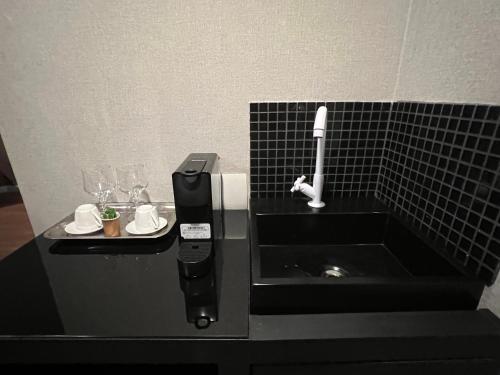 a black counter with a toothbrush and glasses on it at Hotel Wydn Ibirapuera Moema in Sao Paulo