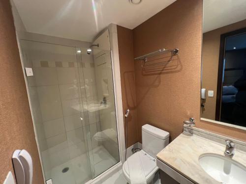 a bathroom with a shower and a toilet and a sink at Hotel Wydn Ibirapuera Moema in Sao Paulo