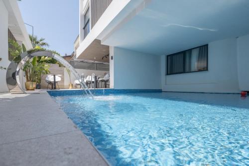 a swimming pool with a fountain in a building at Mad İnn Lara in Antalya