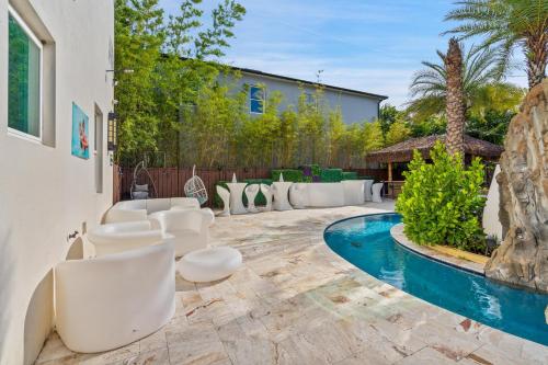 a patio with white chairs and a swimming pool at 1021 Fantasy in Davenport