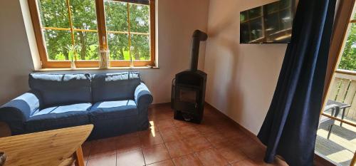 a living room with a couch and a stove at Ferienwohnungen Das Finkhaus in Simonsberg