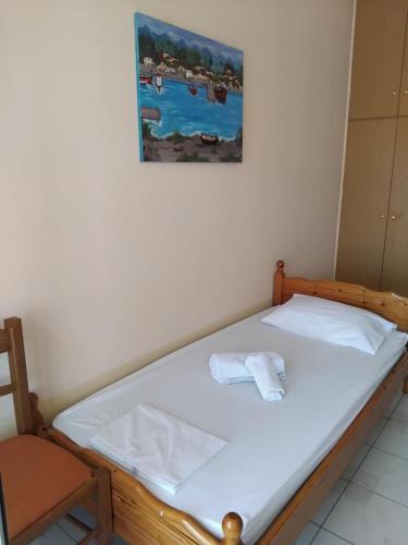a bed in a room with a picture on the wall at Irene's Sunny apartment in Limnos in Néa Koútali