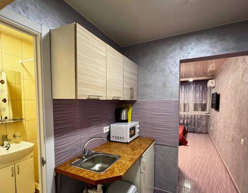 a small kitchen with a sink and a microwave at Apartments Promenad in Zatoka
