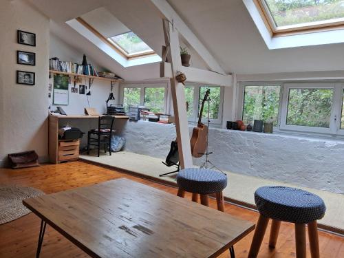 een woonkamer met een tafel en een aantal ramen bij Les bananiers in Bergerac