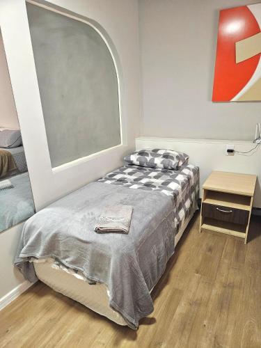 a bedroom with a bed and a large window at Saint Sebastian Flat 716 - Com Hidro! até 3 pessoas, Duplex, no centro in Jaraguá do Sul