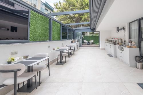 a restaurant with tables and chairs and windows at Mad İnn Lara in Antalya