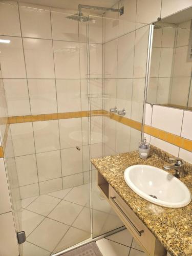 a bathroom with a glass shower and a sink at Saint Sebastian Flat 716 - Com Hidro! até 3 pessoas, Duplex, no centro in Jaraguá do Sul