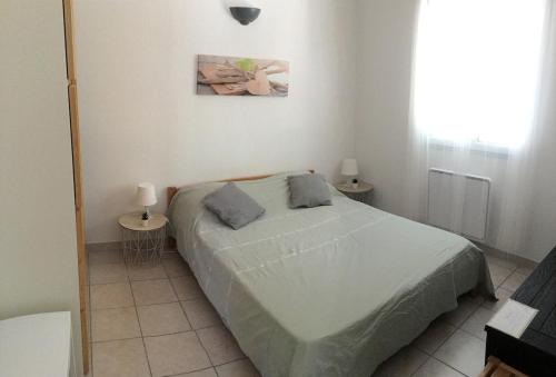 ein Schlafzimmer mit einem großen Bett und zwei Tischen in der Unterkunft Maison indépendante en Drôme Provençale in Valaurie