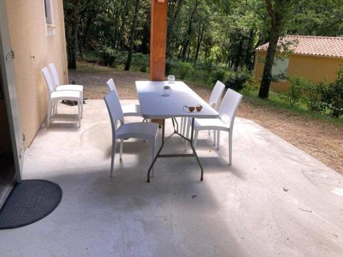 ein weißer Tisch und Stühle auf einer Terrasse in der Unterkunft Maison indépendante en Drôme Provençale in Valaurie