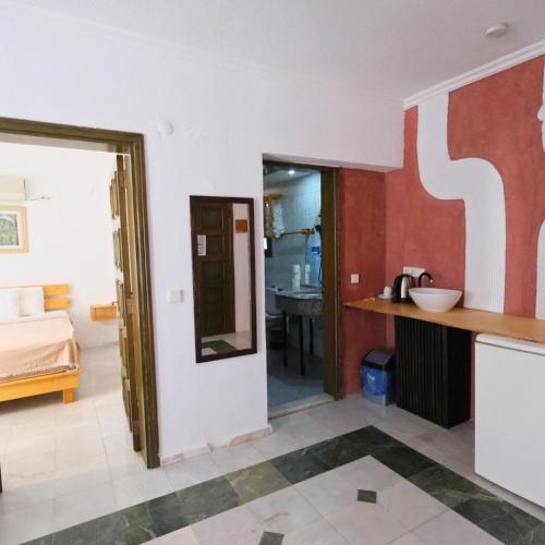 a room with a bed and a bathroom with a sink at Club Mel Holiday in Ortaca