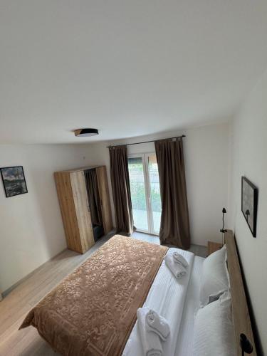 a bedroom with a large bed and a window at Apartman Ćetković in Donji Milanovac