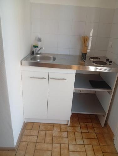 a small white kitchen with a sink and a counter at Maison 2 - entre ville et verdure in Saint-Pryvé-Saint-Mesmin