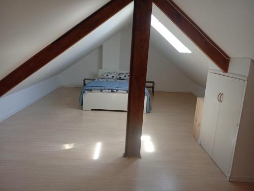 a attic room with a bed and a staircase at Maison 2 - entre ville et verdure in Saint-Pryvé-Saint-Mesmin