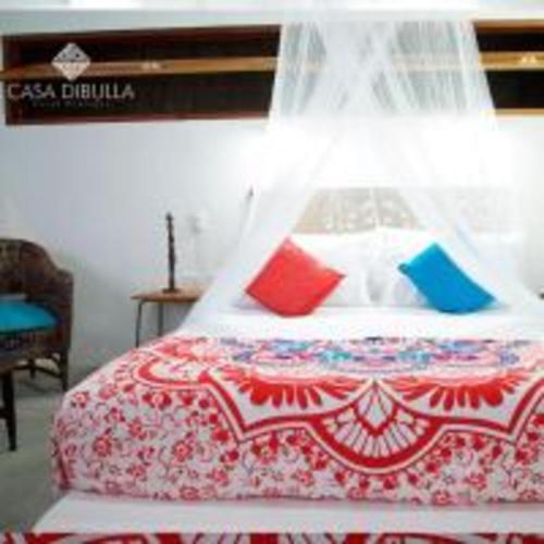 a bed with colorful pillows in a room at Casa Dibulla Hotel Boutique in Dibulla