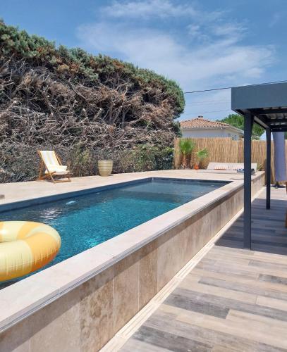 une piscine avec une chaise longue dans une cour arrière dans l'établissement Les Brézines - Maison Clim Terrasse Piscine au cœur de Mus MaisoncarréeConciergerie, à Mus