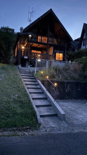 a building with stairs in front of it with lights at ペットと泊まれる貸別荘南阿蘇久木野の郷 in Minami Aso