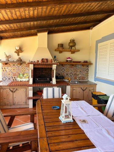a kitchen with a wooden table and a stove at Casa Oasis - Paraiso na Terra in Tunes