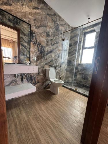 a bathroom with a toilet and a stone wall at villas d'or in Marrakesh