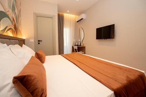 a bedroom with a bed with a television on the wall at Vila Lasko Hotel in Golem