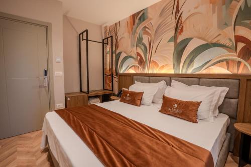 a bedroom with a large bed with a painting on the wall at Vila Lasko Hotel in Golem