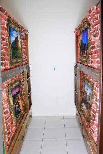 a room with a brick wall with fireplaces at CAMINHOS do VALE EUROPEU HOSTEL in Timbó