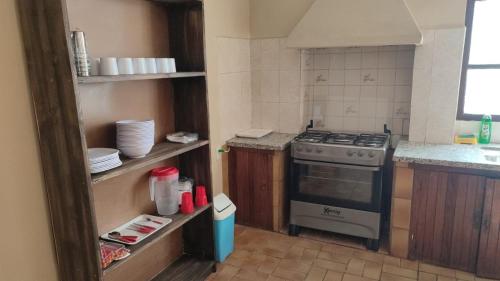 a small kitchen with a stove and a sink at Santa Teresa Alley Hostel in Sucre