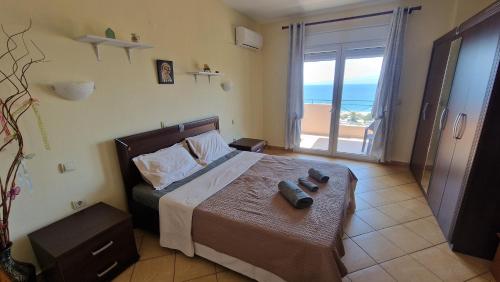 a bedroom with a bed with a view of the ocean at Alexandras Villa in Skala Marion