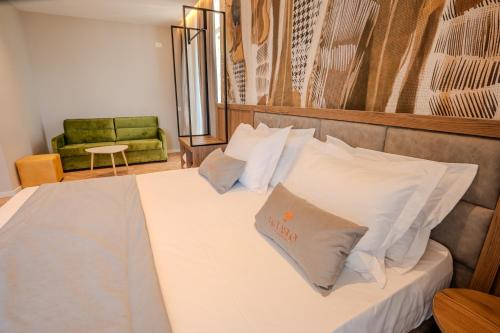 a bedroom with a bed with white sheets and pillows at Vila Lasko Hotel in Golem