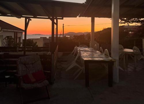 una mesa y sillas en un porche con vistas a la puesta de sol en Villa Conchiglia, en Butera