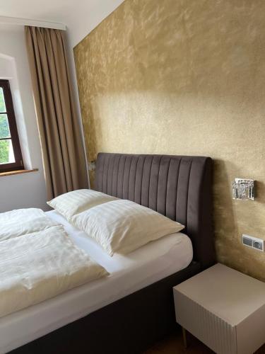 a bed with two pillows on it in a room at Pension & Restaurant Atmosféra in Loket