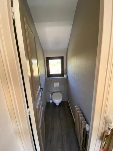 a small bathroom with a toilet and a window at La maison normande in Rots